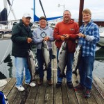 Four men with the fish they caught on hooks